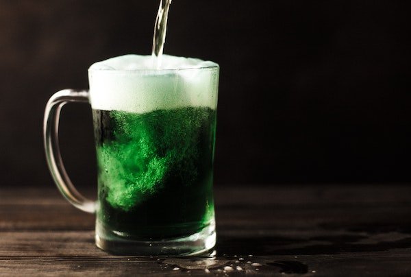 glass of green beer being poured